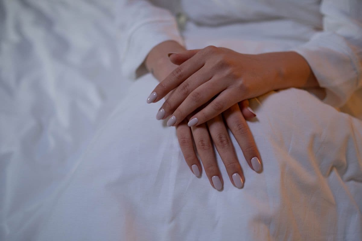 Mãos finalizando esmaltação minimalista